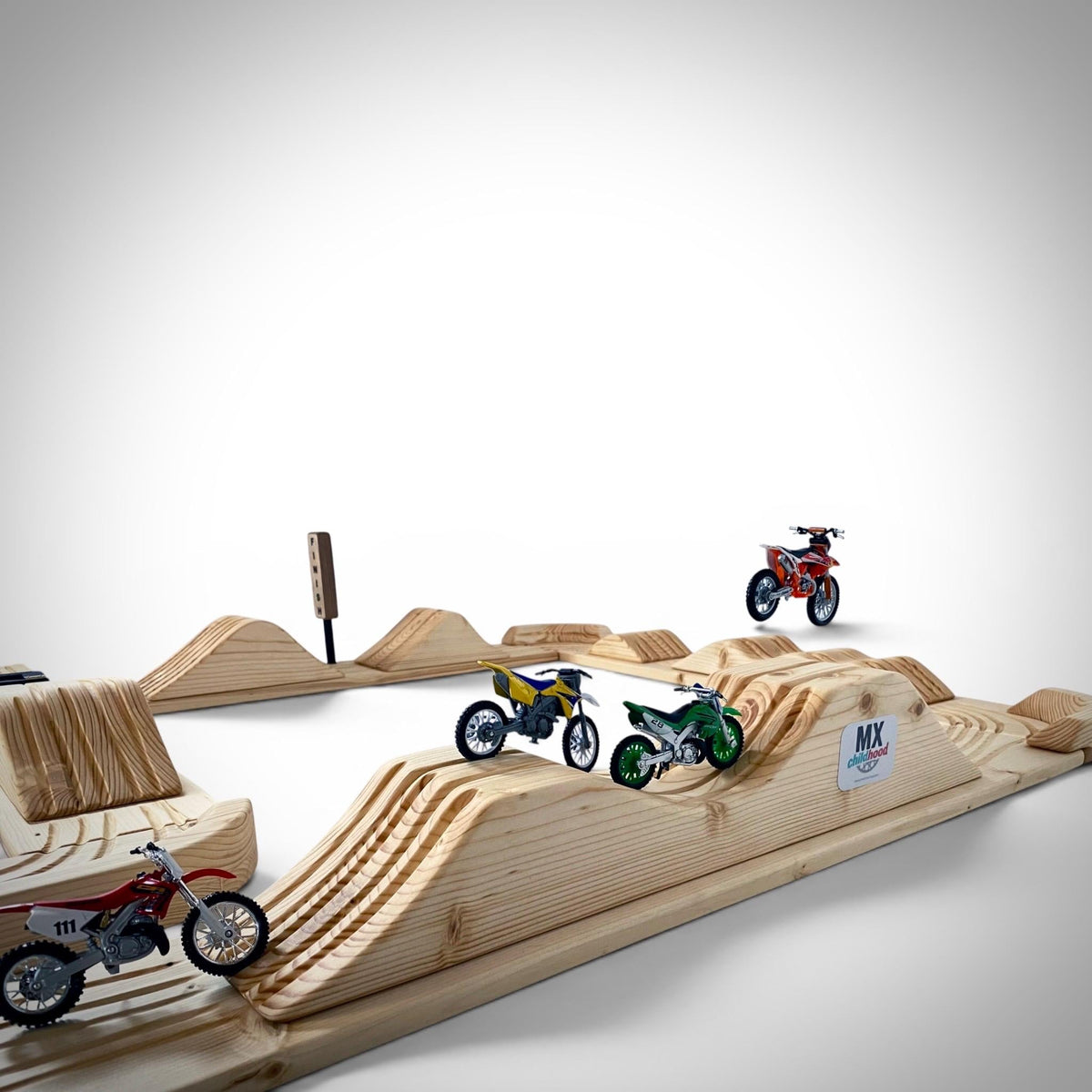 Detailed wooden motocross race track featuring realistic corners, jumps and riding grooves.