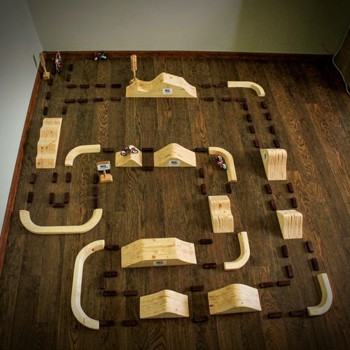 Large handmade wooden motocross track with multiple jumps, bowl turns, tuff blocks and START and FINISH signs.