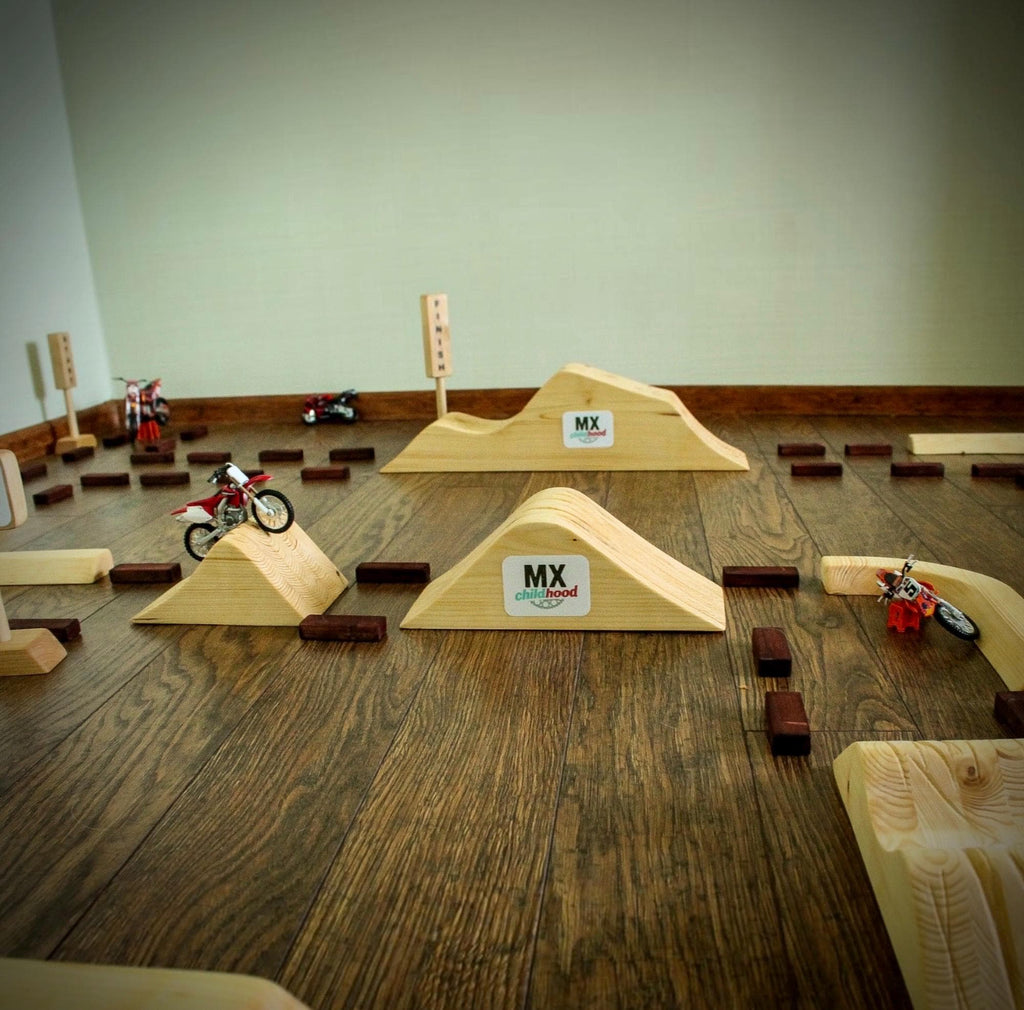 Wooden motocross track with multiple jumps and bowl-style turns arranged in a supercross-inspired layout.