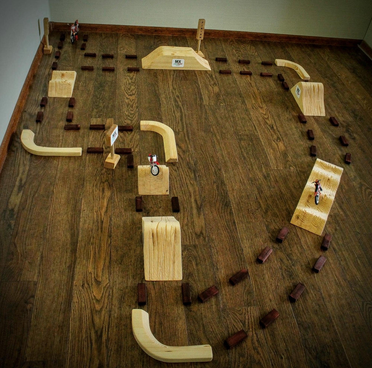 Large wooden motocross racing track for kids, handmade dirt bike playground with realistic jumps and challenging turns.