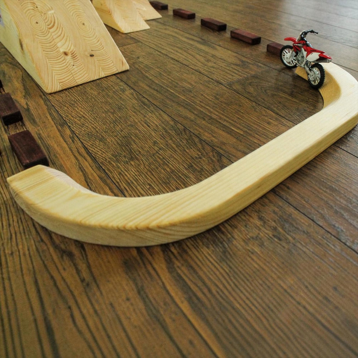 Miniature dirt bike model on an FMX play track for young motofreestyle enthusiasts.